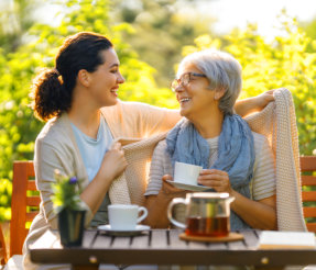 caregiver and elderly laughing together