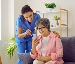 caregiver assessing the elderly while using smart phone