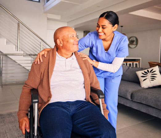 caregiver and elderly man smiling together