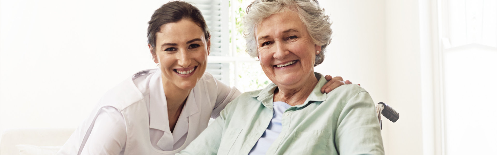 caregiver and elderly woman smiling