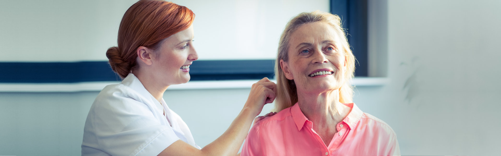 caregiver combing hair of elderly woman