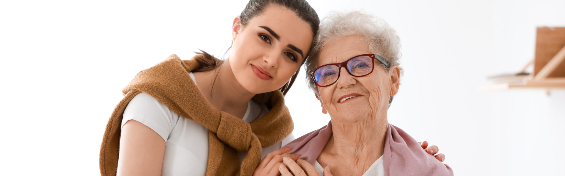 young woman hugging elderly while smiling