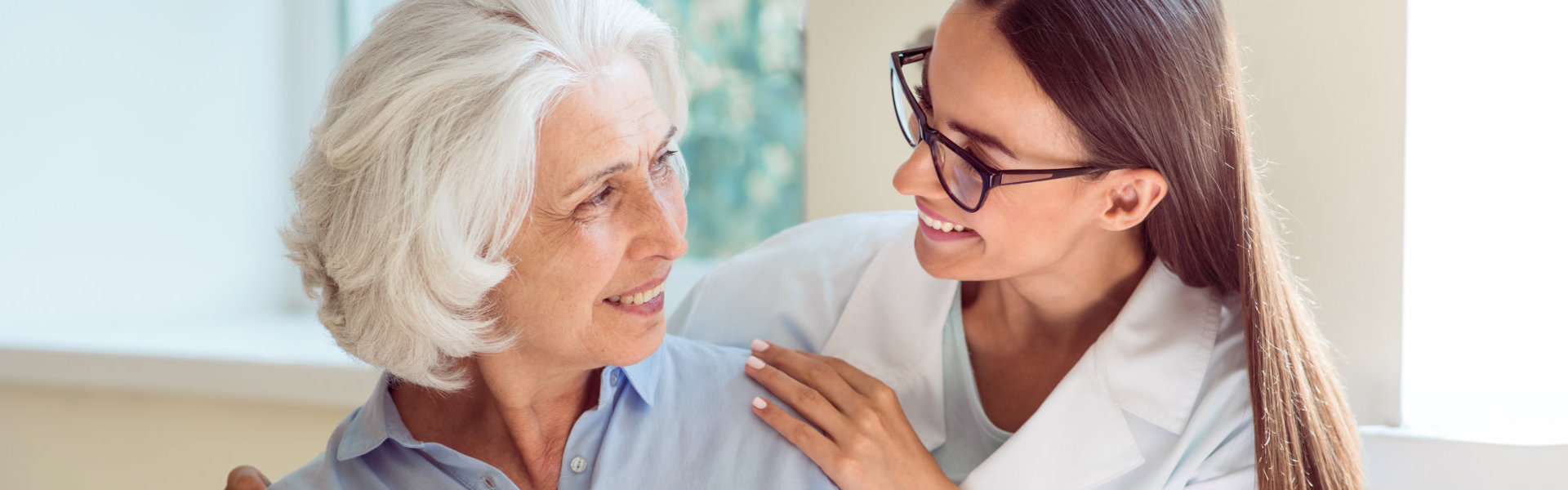 caregiver and elderly woman smiling